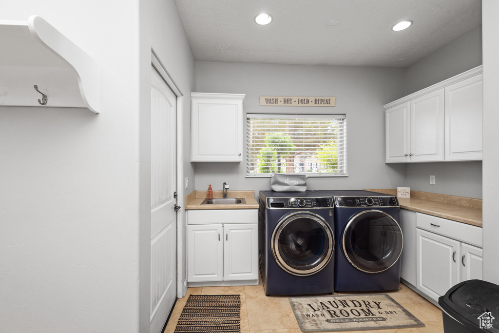Washroom with cabinet space, washer and clothes dryer, recessed lighting, and light tile patterned floors