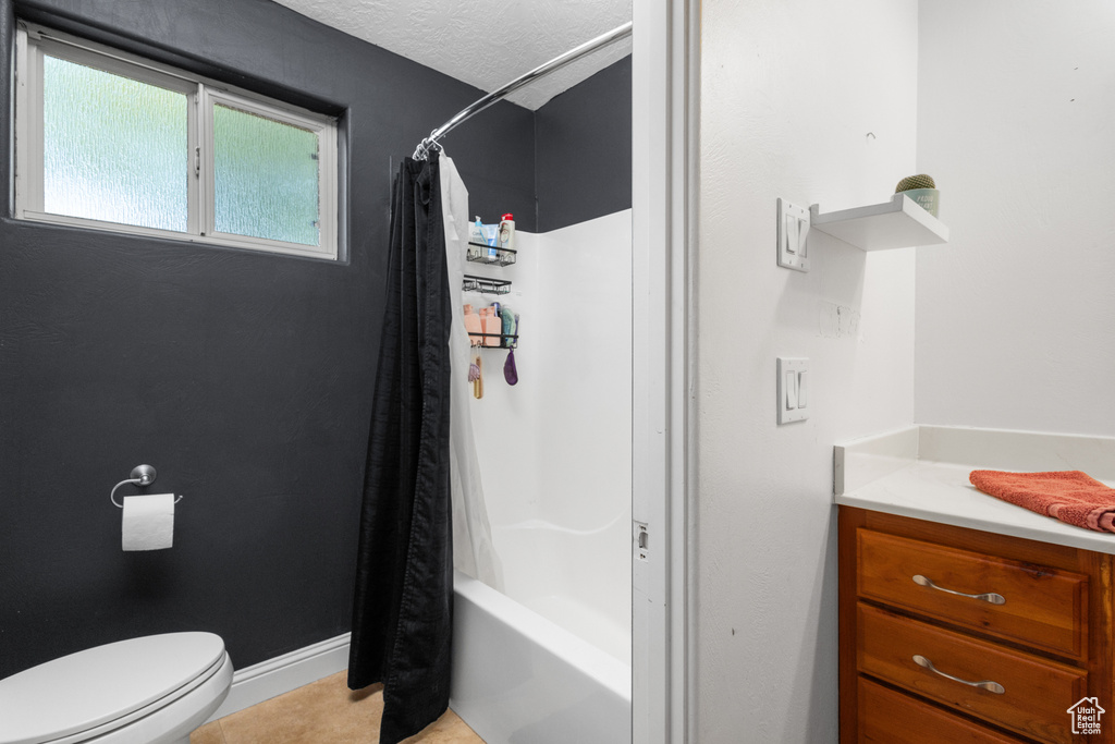 Full bathroom featuring toilet, shower / bathtub combination with curtain, and vanity
