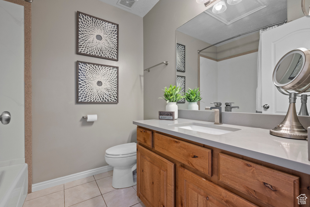 Full bath featuring toilet, tile patterned flooring, baseboards, vanity, and  shower combination