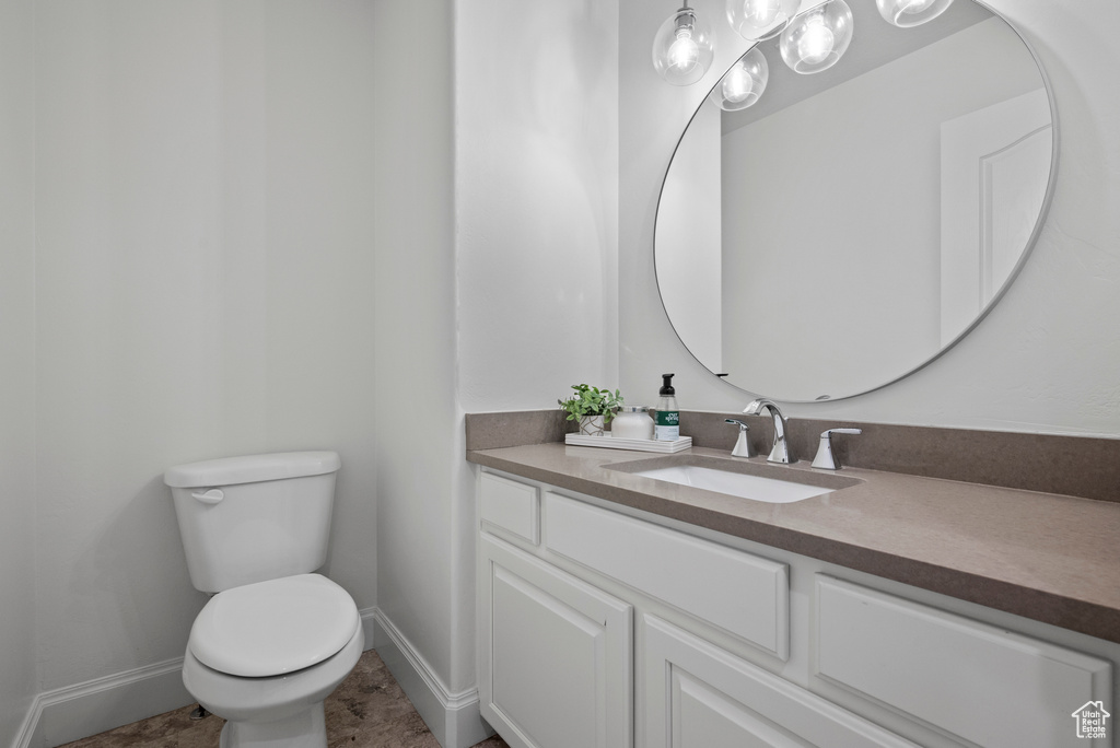 Bathroom with toilet, baseboards, and vanity