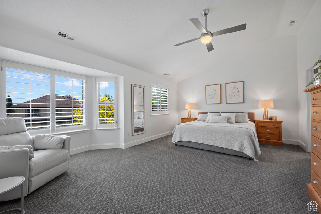 Bedroom with dark carpet, baseboards, vaulted ceiling, and a ceiling fan