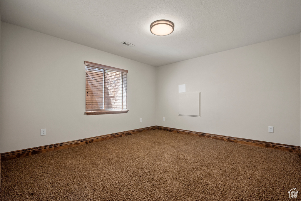 Carpeted spare room with baseboards