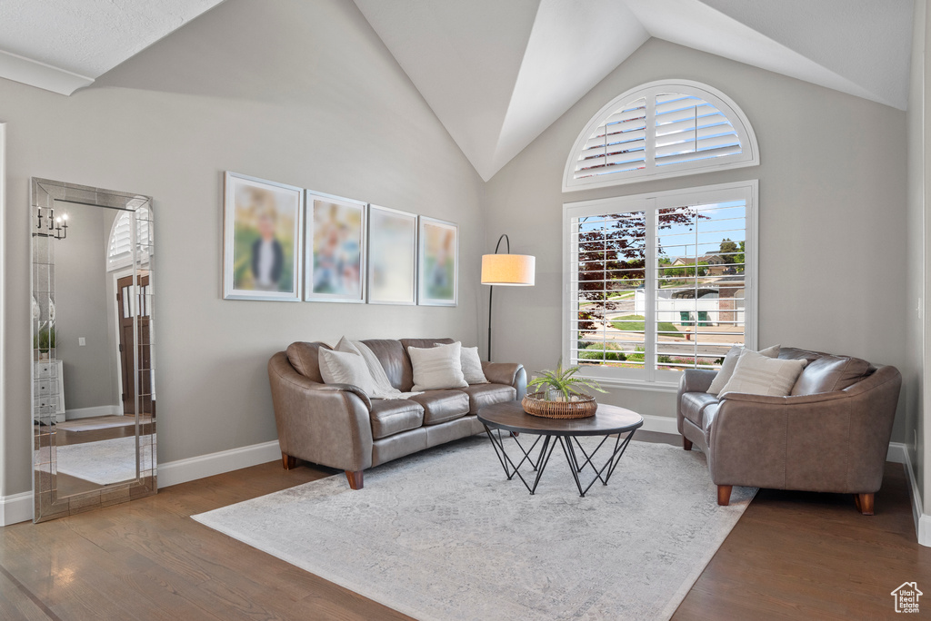 Living area featuring wood finished floors, lofted ceiling, and baseboards