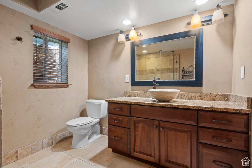 Full bathroom with a shower, toilet, baseboards, tile patterned flooring, and vanity