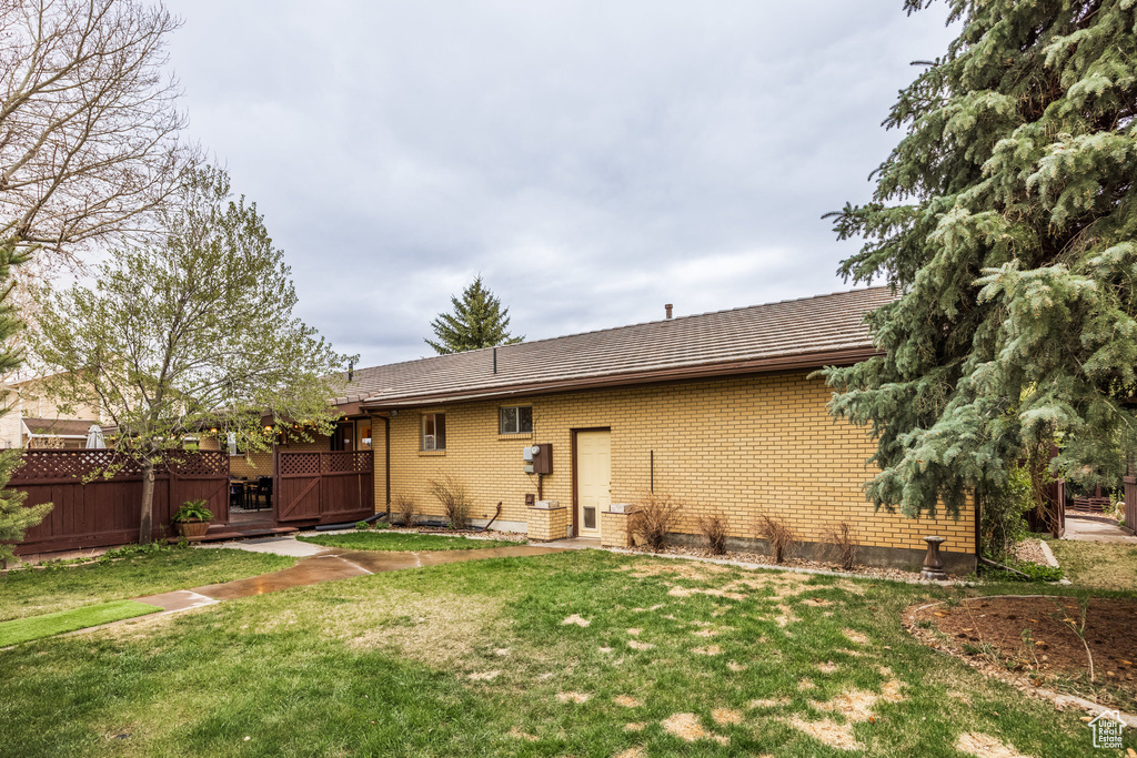 Back of house with brick siding and a wooden deck