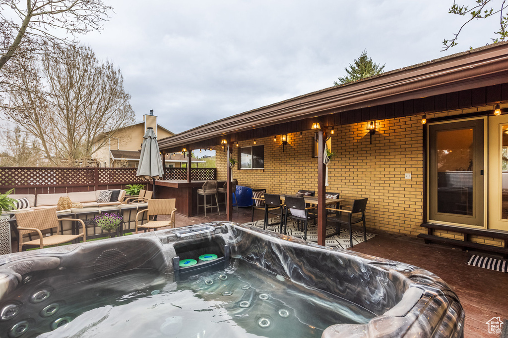 View of swimming pool featuring a hot tub, fence, a patio area, and outdoor lounge area