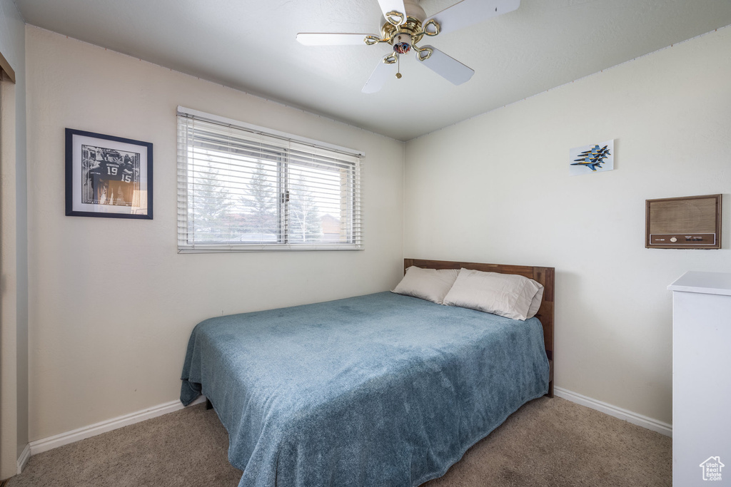 Carpeted bedroom with baseboards and ceiling fan