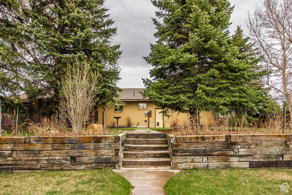 Obstructed view of property with brick siding and a front yard