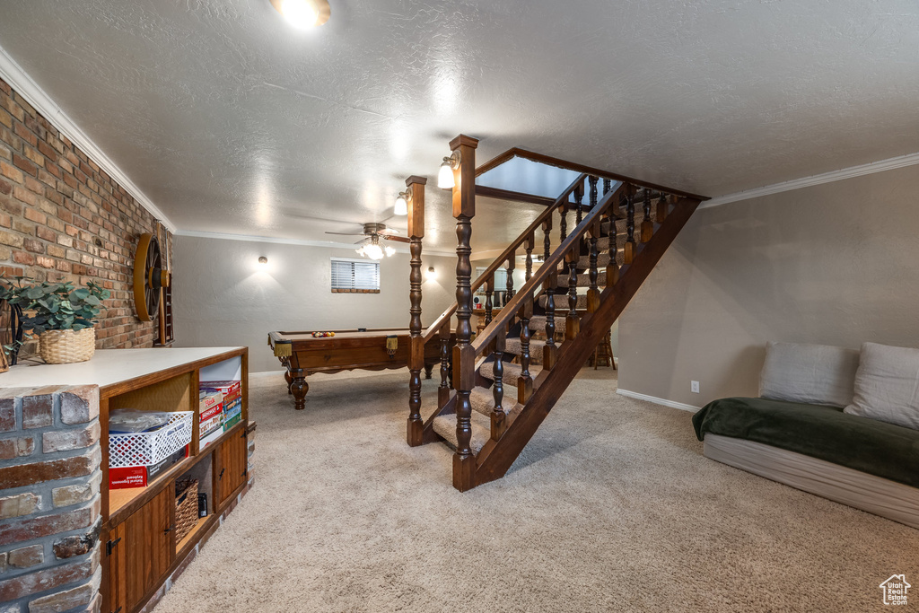 Living room featuring billiards, light carpet, a textured ceiling, ceiling fan, and crown molding