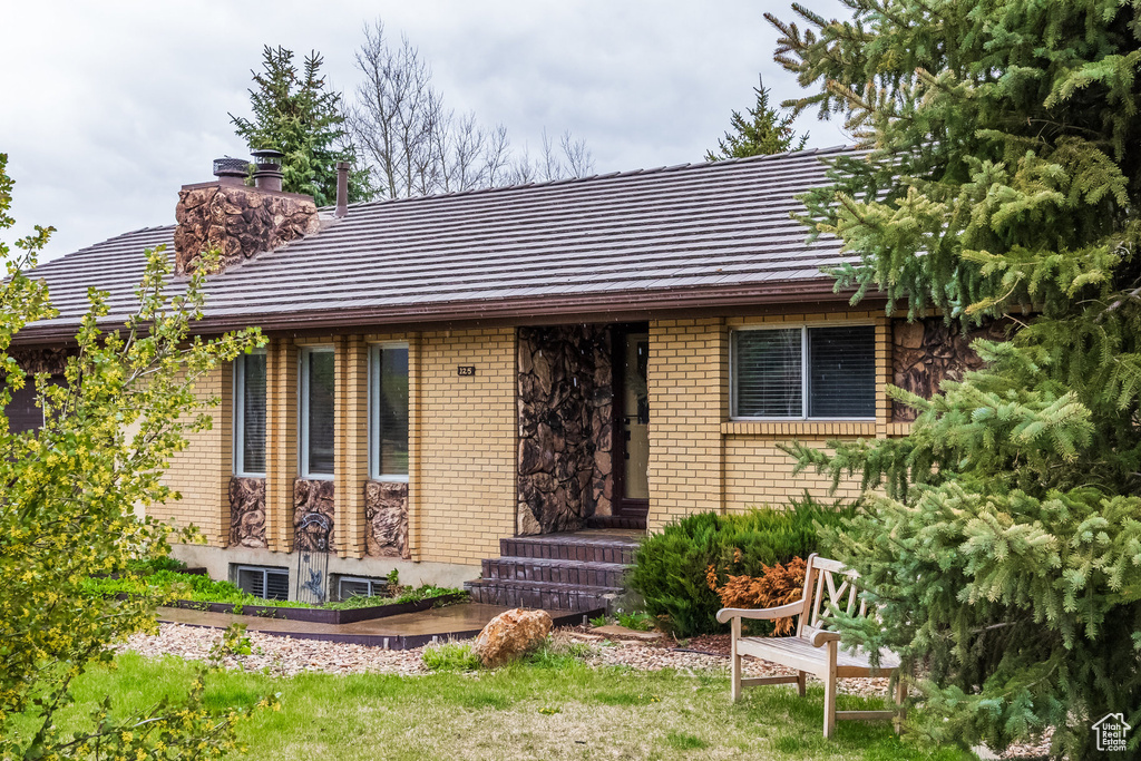 View of front of home featuring a chimney and brick siding