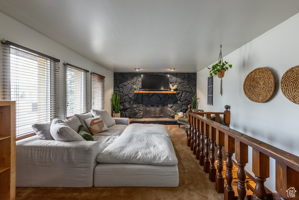 Carpeted living area featuring plenty of natural light and a fireplace