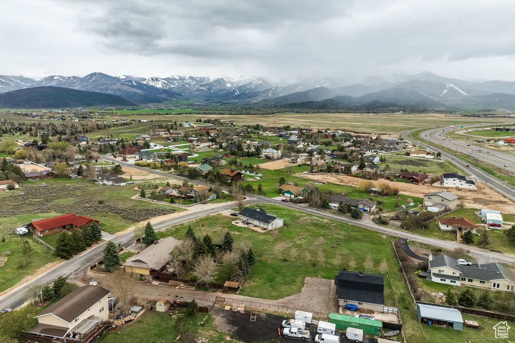 Aerial view of property and surrounding area with a mountainous background and nearby suburban area