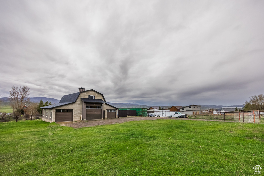 View of yard featuring a garage, an outdoor structure, and a barn