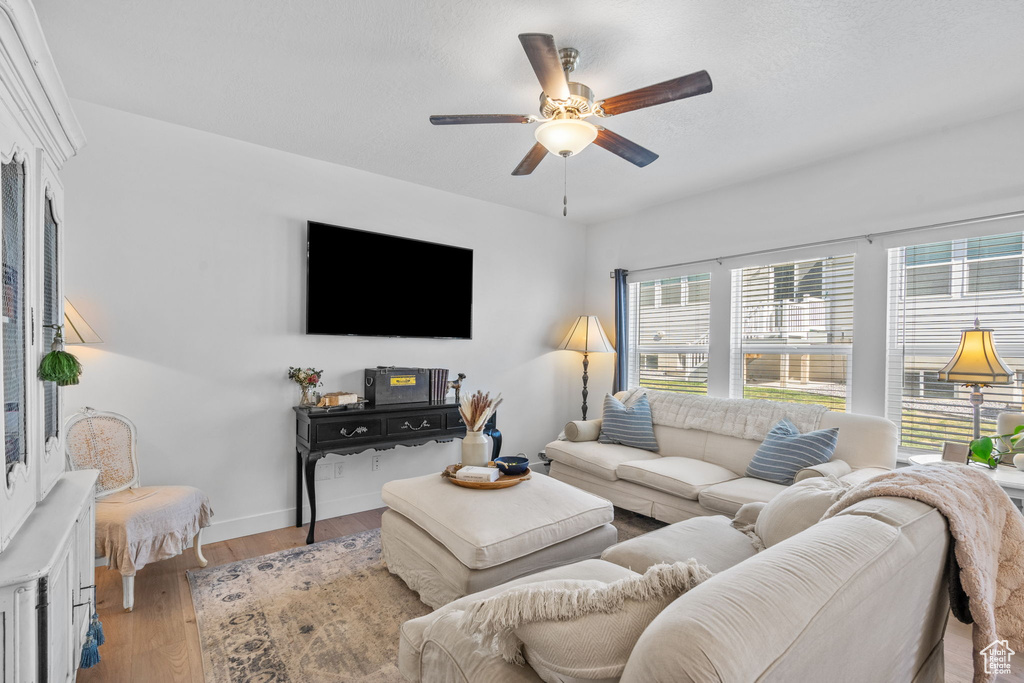 Living room featuring plenty of natural light, ceiling fan, wood finished floors, and baseboards