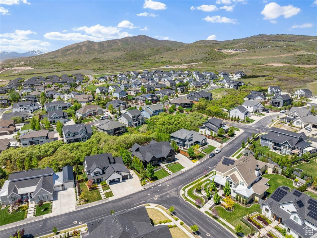 Aerial view of property and surrounding area with nearby suburban area and mountains