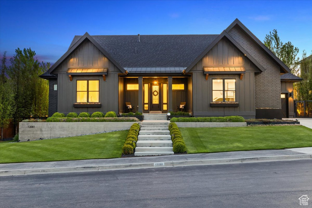 Modern inspired farmhouse featuring a standing seam roof, board and batten siding, metal roof, and a front lawn