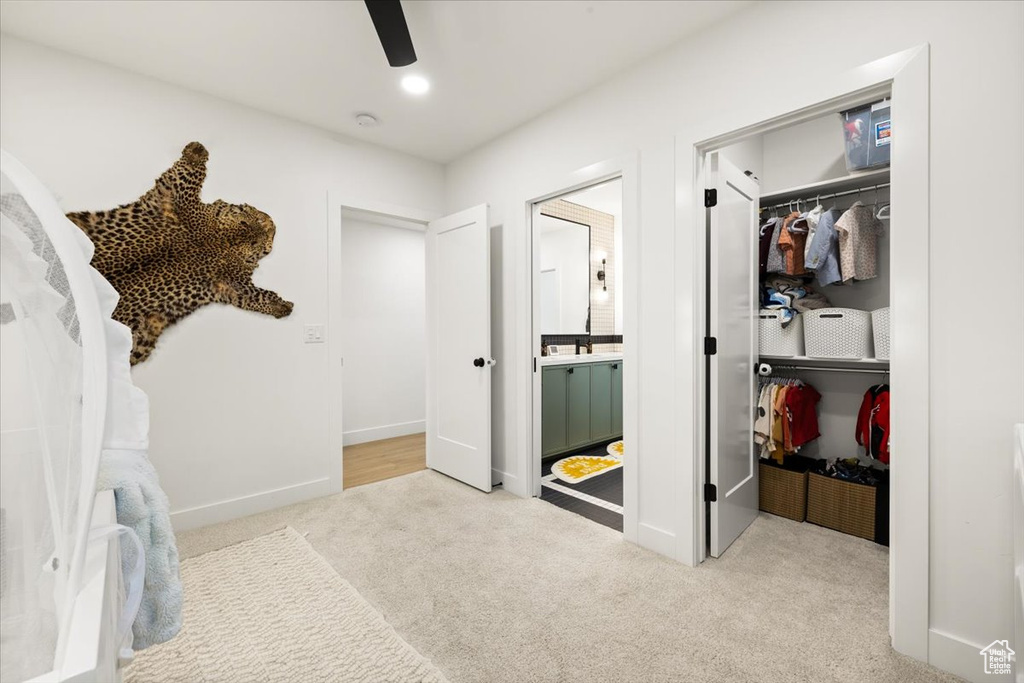 Walk in closet with carpet and a ceiling fan