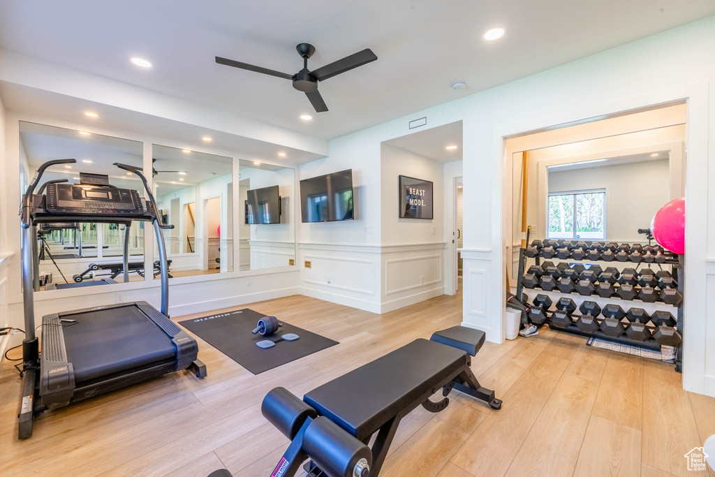 Workout area with ceiling fan, light wood-style floors, wainscoting, a decorative wall, and recessed lighting