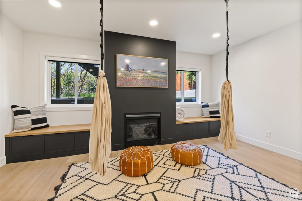 Living area with wood finished floors, baseboards, recessed lighting, and a fireplace