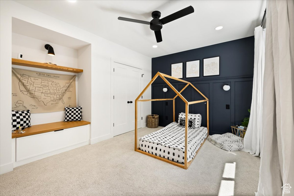 Carpeted bedroom featuring recessed lighting, ceiling fan, and a decorative wall