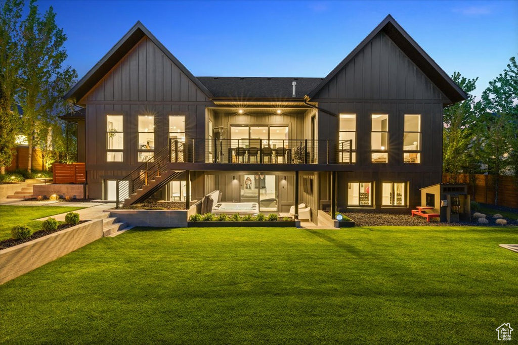 Rear view of house featuring board and batten siding, stairs, and a wooden deck