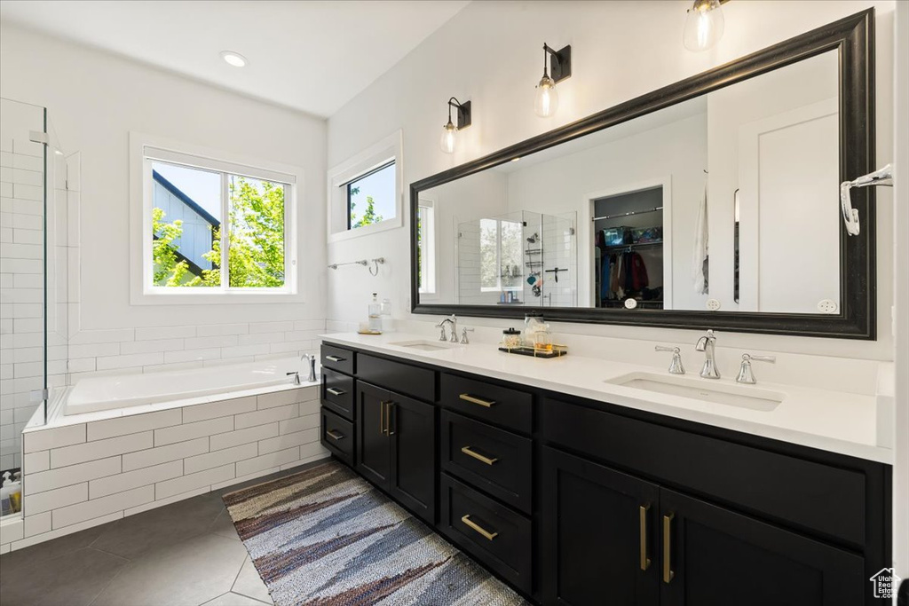 Bathroom with a shower stall, a garden tub, tile patterned flooring, and double vanity