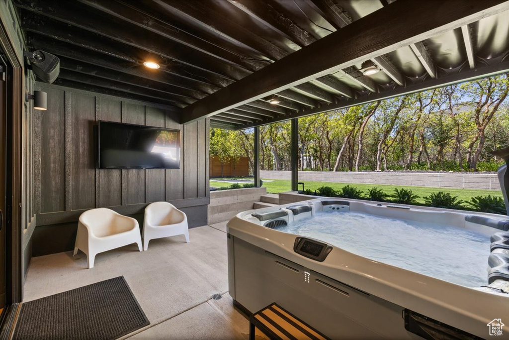 View of patio / terrace with a hot tub and view of scattered trees