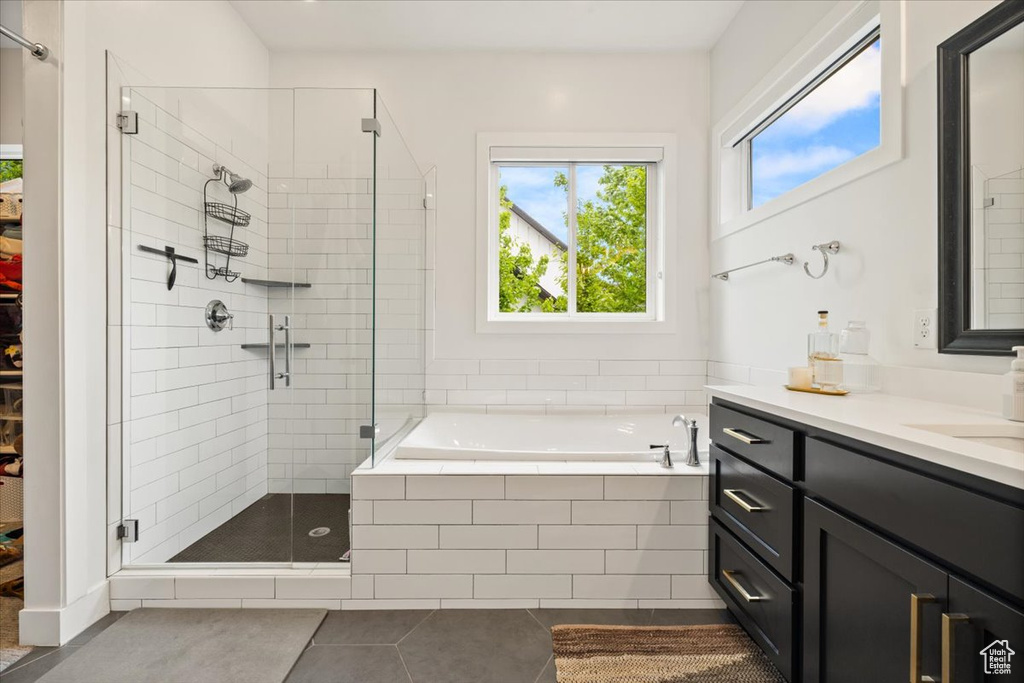 Full bathroom featuring tile patterned floors, a shower stall, a garden tub, and vanity