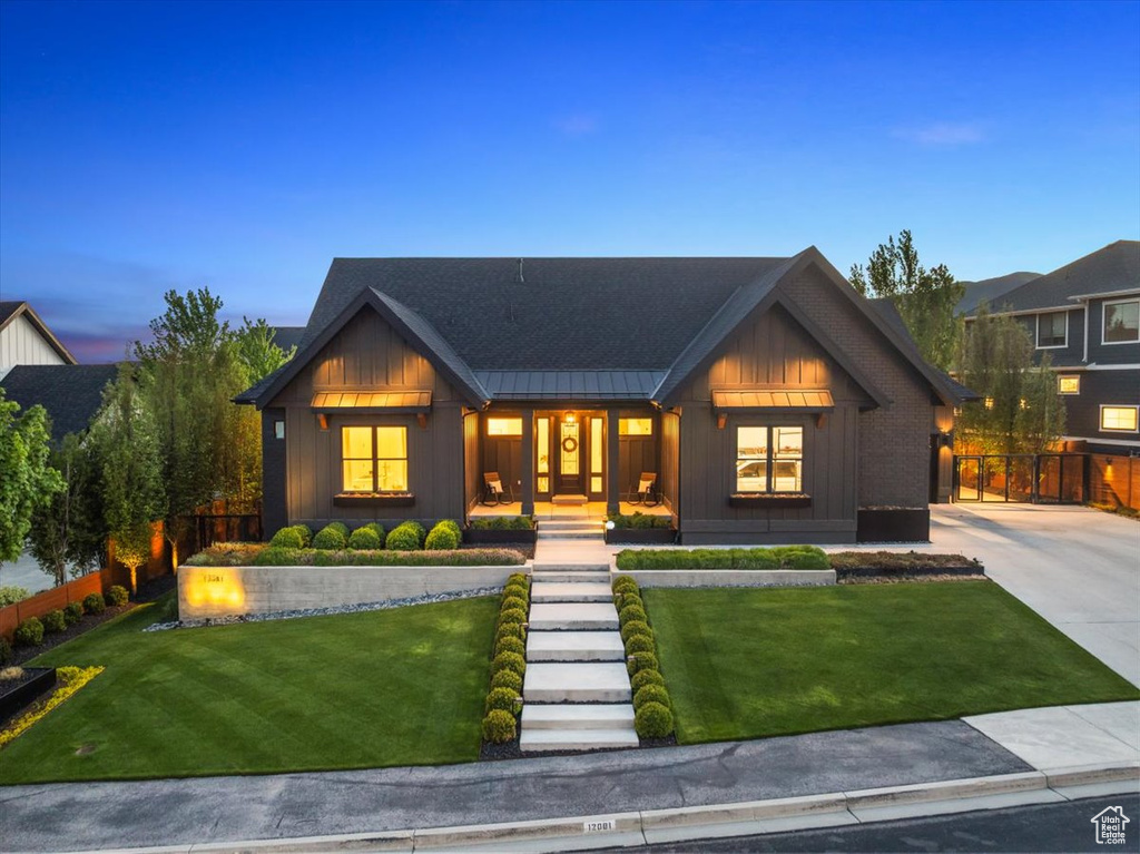 Modern farmhouse with board and batten siding, a porch, a standing seam roof, and metal roof