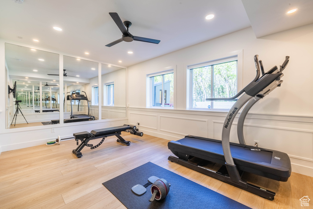 Workout room with ceiling fan, healthy amount of natural light, a decorative wall, wainscoting, and recessed lighting