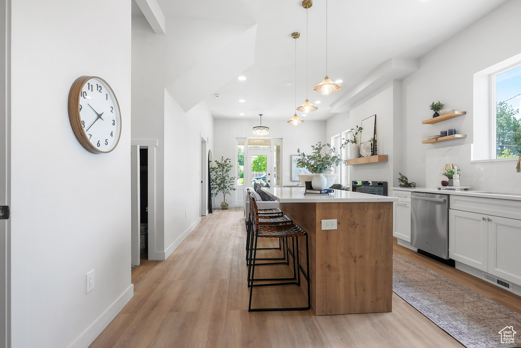 Kitchen featuring stainless steel dishwasher, open shelves, a kitchen island, light wood finished floors, and recessed lighting