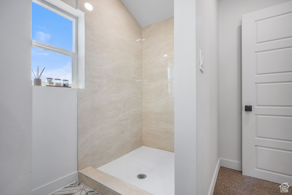 Full bath with baseboards and tiled shower