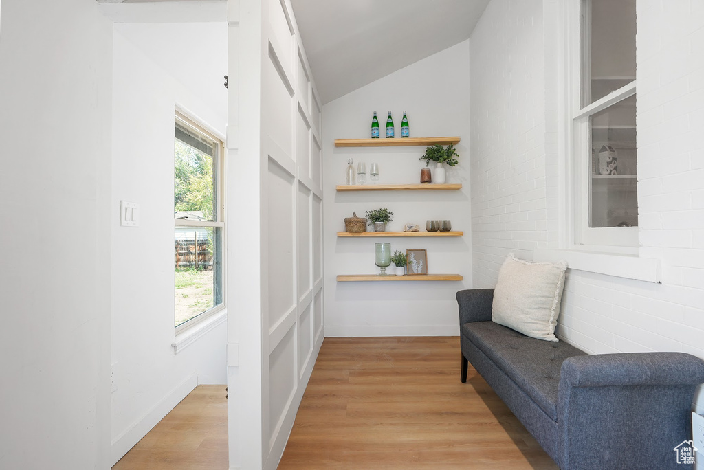 Sitting room with light wood finished floors and lofted ceiling