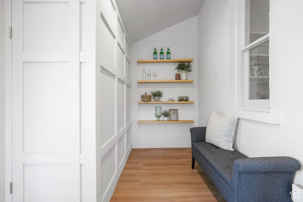 Sitting room with light wood finished floors and lofted ceiling