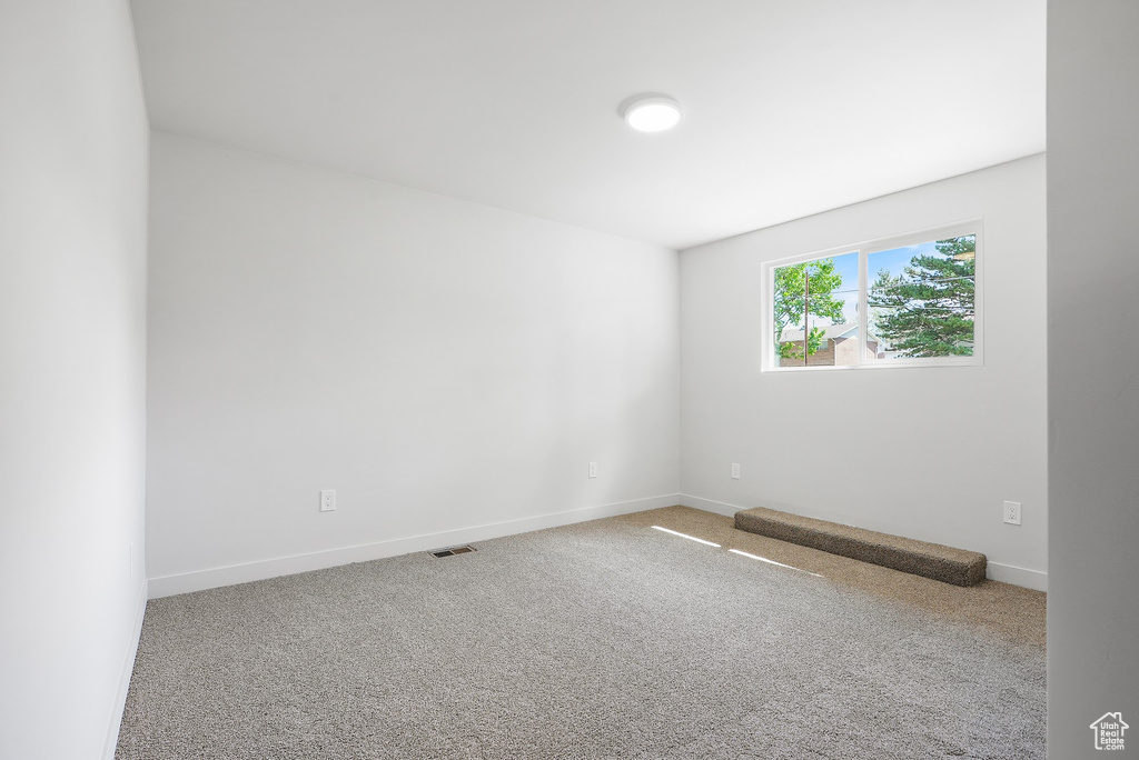 Carpeted empty room with baseboards