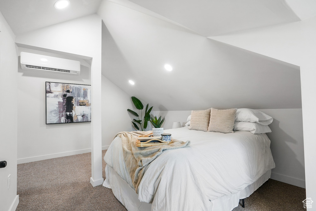 Bedroom featuring lofted ceiling, a wall unit AC, carpet floors, recessed lighting, and baseboards