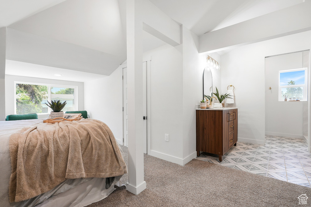 Bedroom featuring vaulted ceiling, baseboards, and light colored carpet