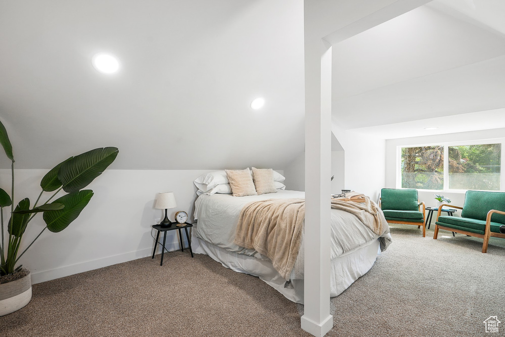 Bedroom featuring carpet floors, lofted ceiling, and baseboards