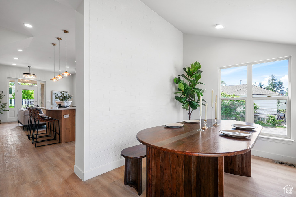 Dining space featuring light wood finished floors, vaulted ceiling, baseboards, and recessed lighting