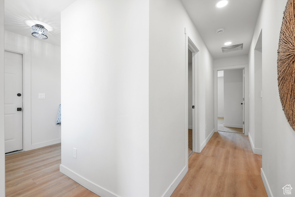 Hallway with recessed lighting, light wood-style floors, and baseboards