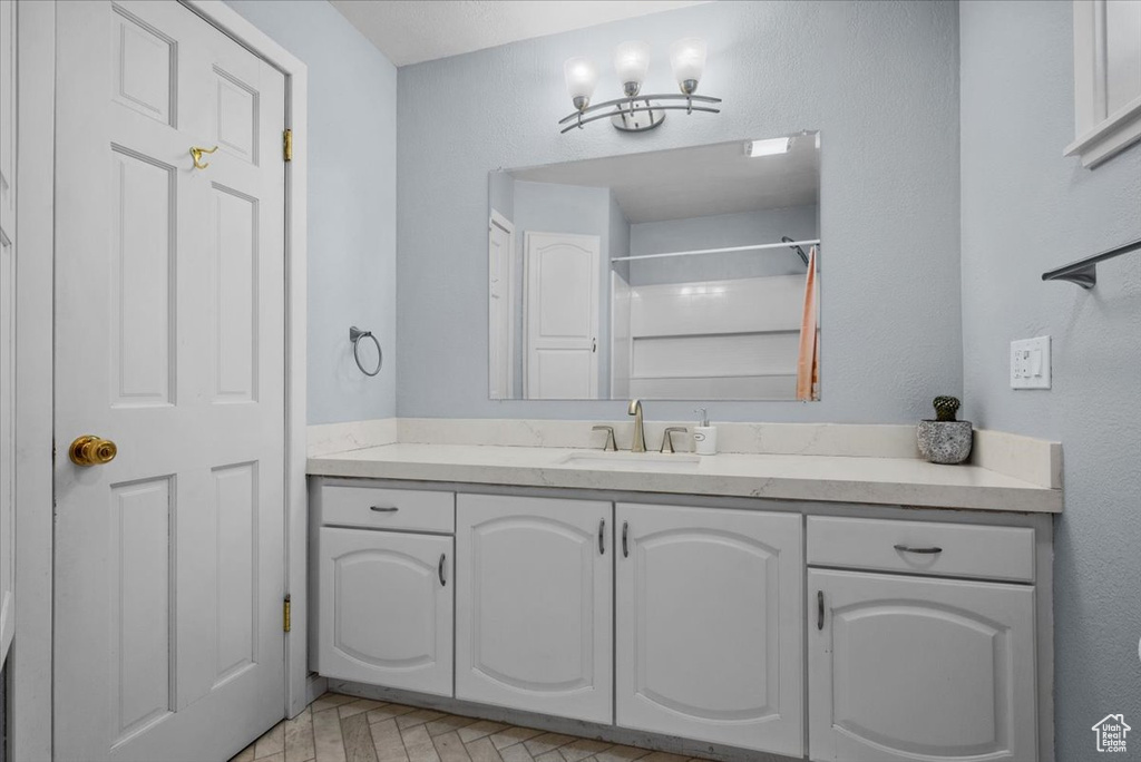 Bathroom featuring vanity and a shower