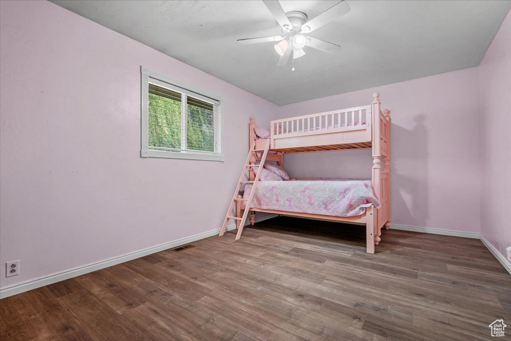 Bedroom with wood finished floors, baseboards, and ceiling fan