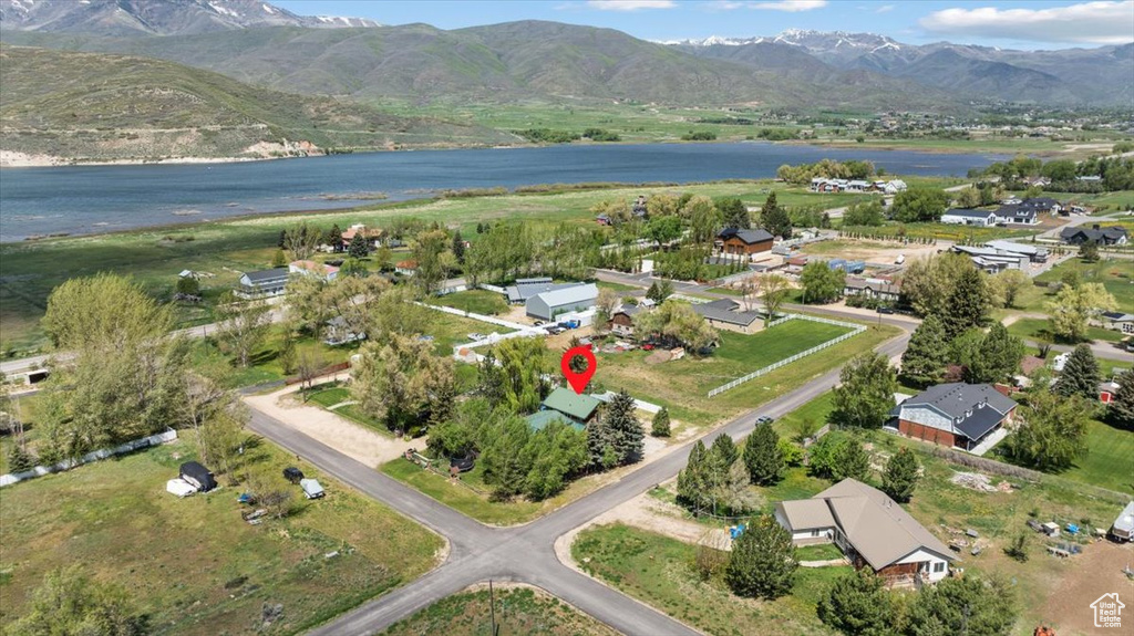 Aerial view of property and surrounding area with a water and mountain view