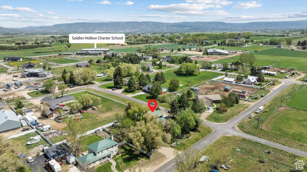 Aerial view of property and surrounding area with a mountainous background