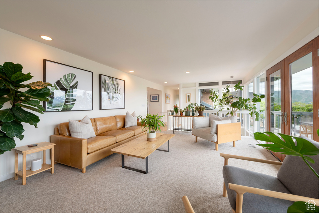 Living area with light carpet, french doors, and recessed lighting