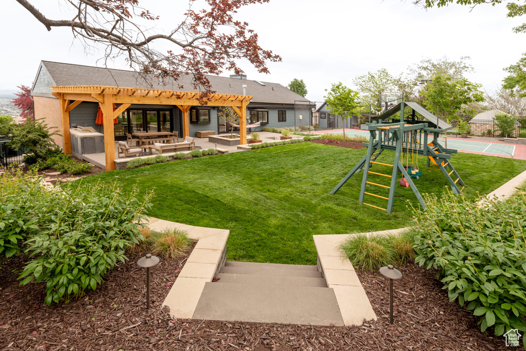 View of green lawn featuring a pergola and a patio area