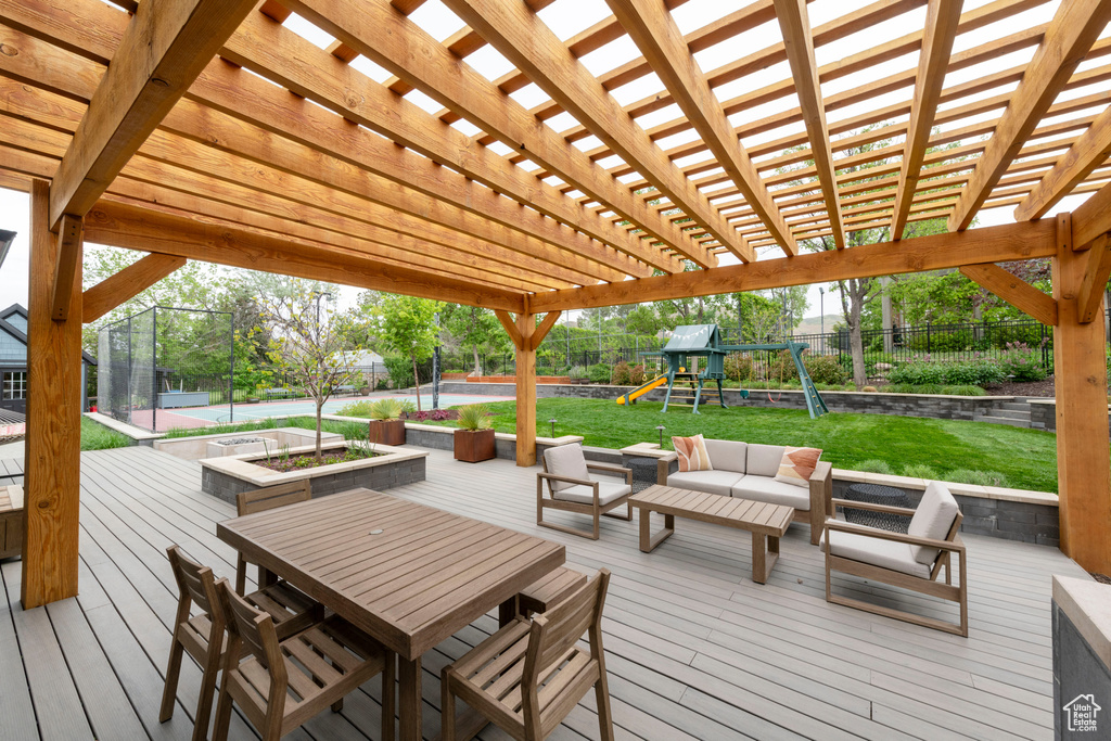 Wooden deck featuring a playground, outdoor lounge area, and a pergola