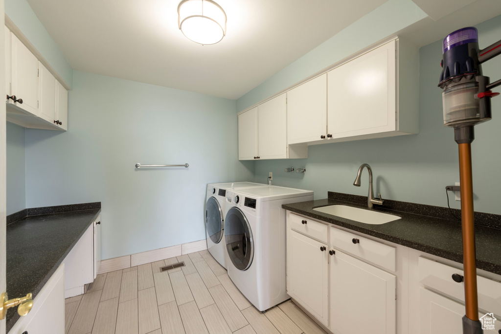Laundry room with cabinet space, washing machine and clothes dryer, and baseboards