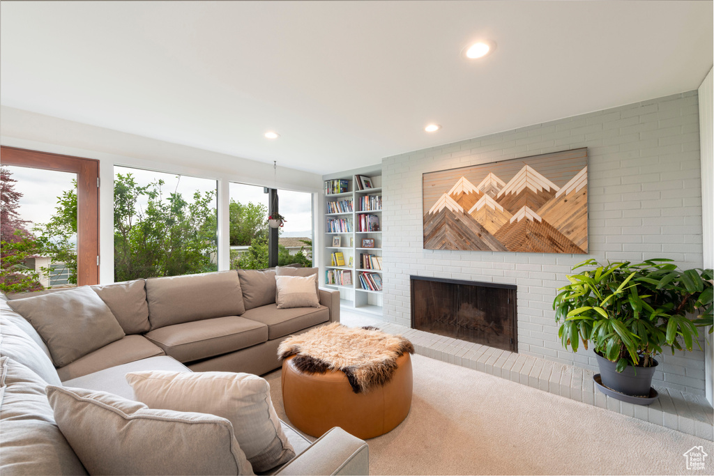 Living room with a fireplace, recessed lighting, carpet, and built in features