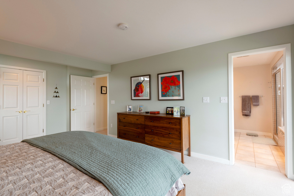 Bedroom featuring light carpet, baseboards, and connected bathroom